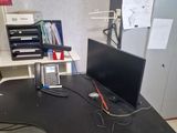 a black desk with a laptop and a phone on it