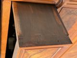 a close up view of a wooden dresser with a drawer underneath it