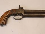 gros plan d'un pistolet sur une table à fond blanc