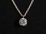 a white diamond pendant on a silver chain