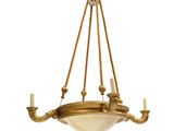 un lustre ancien en laiton avec des abat-jours en verre et des bougies