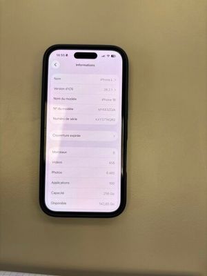 Un iPhone est posé sur une table près d'un mur.