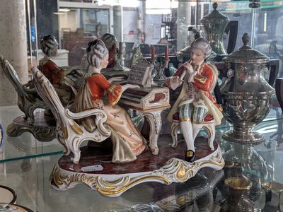 some figurines are sitting on a glass shelf in a glass case