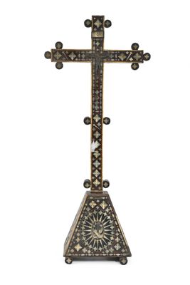 an ornate cross on a stand on a white background