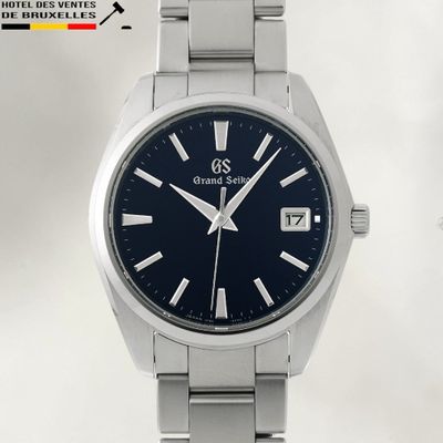 a close up of a wrist watch with a blue dial