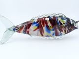 a glass fish that is sitting on a white surface