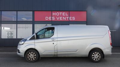La camionnette blanche est garée devant l'Hôtel des Ventes.
