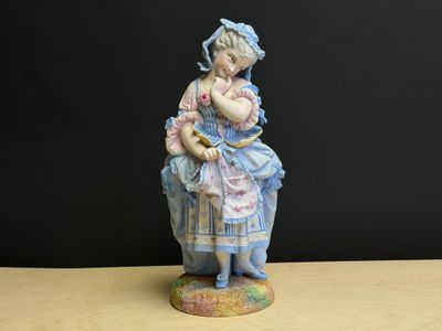 une figurine représentant une petite fille tenant un chat dans ses bras