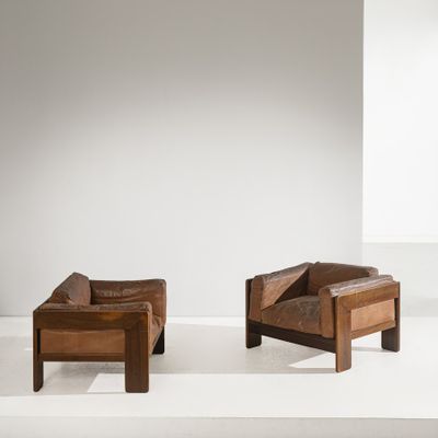 deux fauteuils en cuir marron posés sur une estrade blanche