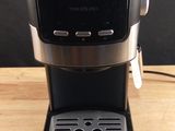 a close up of a black coffee maker on a wooden table