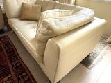 a white couch sitting in a living room next to a window