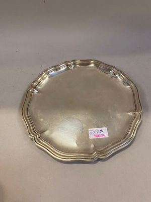une assiette en argent posée sur une table, sur laquelle est collé un autocollant