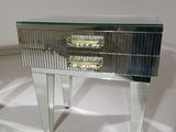 a mirrored table with a drawer on top of it