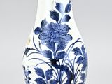 a blue and white vase with flowers on it