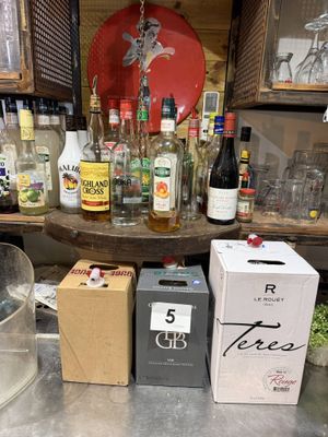 de nombreuses bouteilles d'alcool posées sur un comptoir à côté de cartons