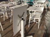 many white chairs and tables on the deck of a restaurant