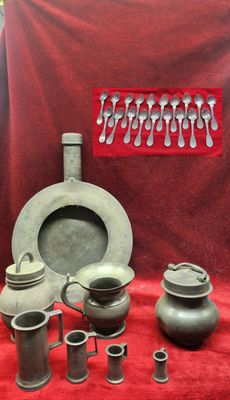 many different types of pottery on display on a red cloth