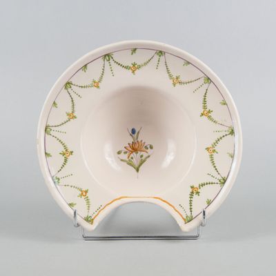 a close up of a bowl on a stand on a gray surface
