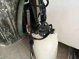 a white bucket with a black handle next to a trash can