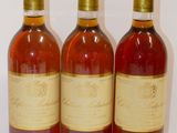 three bottles of wine are lined up on a white surface