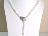 pearl and silver necklace on mannequin display with white background