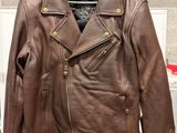 brown leather jacket hanging on a hanger in a clothing store