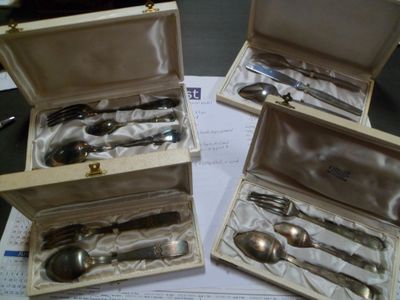 trois cuillères en argent dans une boîte en bois posée sur une table
