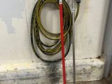 a red broom and a hose on the floor