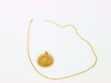 collier plaqué or avec un pendentif en forme de rayons de soleil sur fond blanc