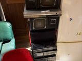 a stack of microwaves sitting on top of a stack of chairs