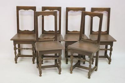 four chairs are lined up in a row on a white surface