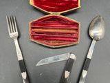 un couteau, une fourchette, une cuillère et un étui posés sur une table