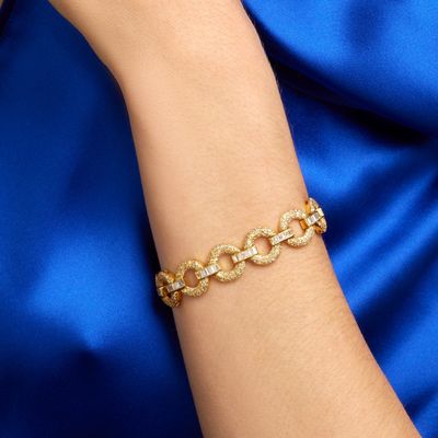 a close up of a woman ' s arm wearing a gold chain bracelet