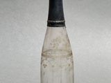 a small glass bottle with a black top on a table