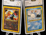 Deux cartes Pokémon sont présentées dans des pochettes en plastique sur un fond noir.