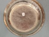 a silver plate on a table with a small stick in it