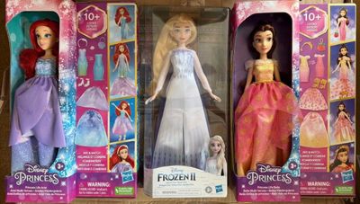 Trois poupées Barbie Princess sont dans leurs boîtes, posées sur une table