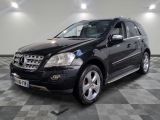 une photo d'un SUV Mercedes noir garé dans un garage