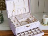 a purple box with jewelry inside sitting on a dresser