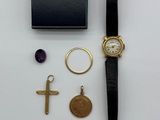 un gros plan d'une montre et d'autres objets posés sur une surface blanche