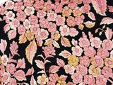 the back of a black shirt with pink and yellow flowers on it