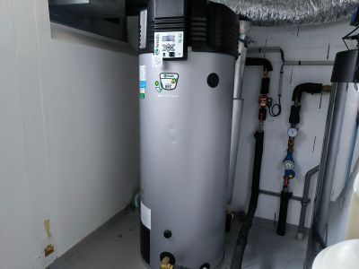 un chauffe-eau installé dans un coin de la pièce, à côté des toilettes