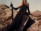 a woman that is sitting on a rock with a sword