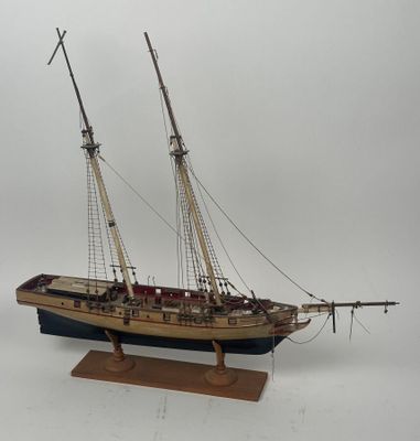 une petite maquette de bateau posée sur un socle en bois