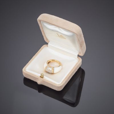 une bague en or dans une boîte blanche posée sur une surface noire