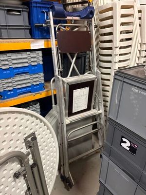 une pile de chaises et un téléviseur dans un entrepôt