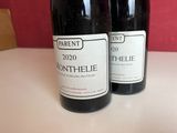 two bottles of wine sitting on a table next to each other