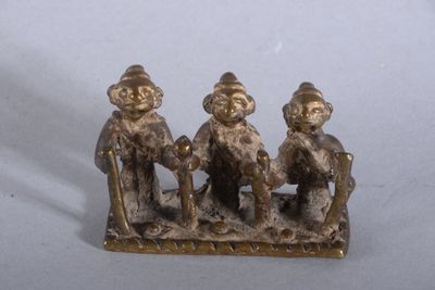 trois figurines représentant trois personnes assises sur un banc