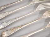five forks and two spoons sitting on a table