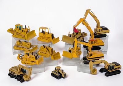 tout un tas de petits engins de chantier en jouets posés sur une table